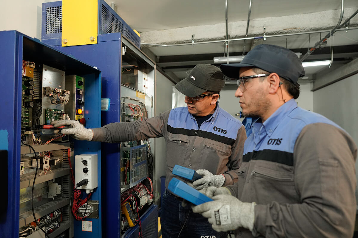 Técnicos da Otis fazendo manutenção de elevadores