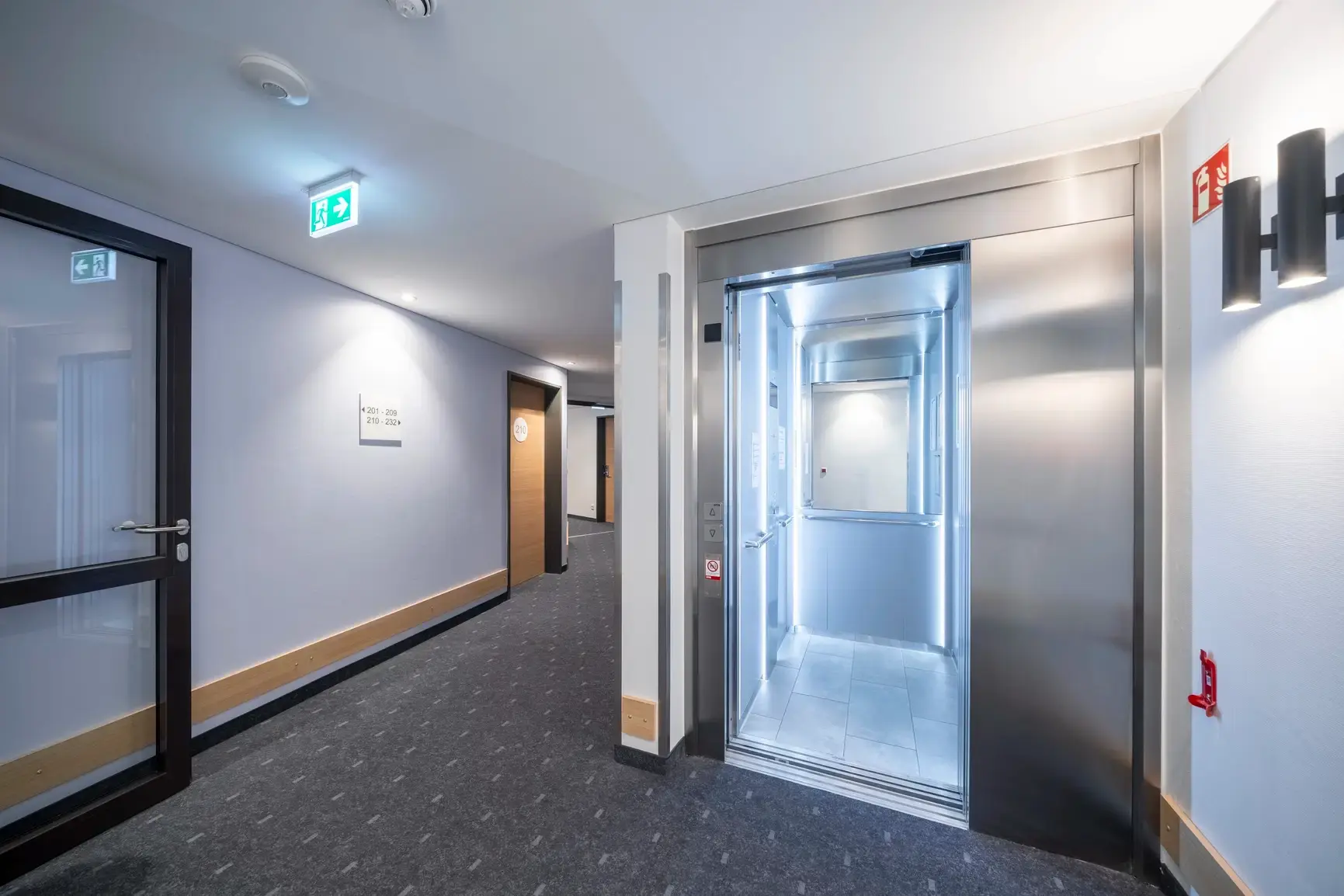 Elevador iluminado em corredor de edifício
