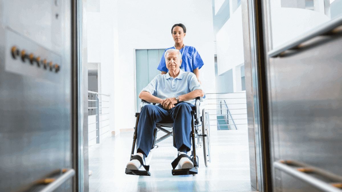 Paciente e enfermeira em elevador hospitalar