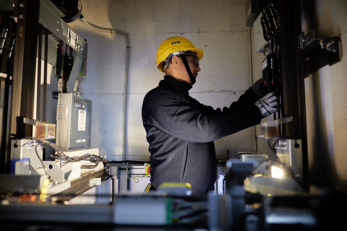 Técnico da Otis inspecionando elevador